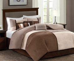 a bed in a bedroom with brown and white comforters