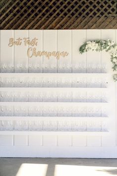 there is a wine glass display on the wall with champagne glasses in front of it