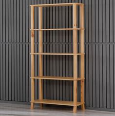 a tall wooden shelf with three shelves on each side, against a gray wall behind it