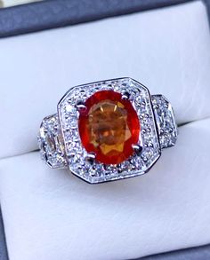 BRAND-NEW!! ONE OF A KIND, HANDCRAFTED RING. ART DECO STYLE! VIVID ORANGE SAPPHIRE RING! GORGEOUS design with sparkling, natural diamonds. This ring offers an important statement of who you are with a large 2.44 carats, VIVID REDDISH ORANGE, transparent SAPPHIRE. Accentuating the sapphire are the 82 E/VVS, and sparkling natural diamonds! Set in handmade 18K solid white gold ring. THE ITEM YOU SEE IN THE PICTURES IS THE EXACT ITEM YOU WILL GET! ONE OF A KIND, NO DUPLICATES OR TWINS SUGGESTED RETA Fine Jewelry Orange Sapphire Anniversary Ring, Orange Sapphire Ring For Anniversary, Orange Sapphire Wedding Ring, Wedding Jewelry With Brilliant Cut In Orange, Orange Brilliant Cut Jewelry For Weddings, Wedding Orange Brilliant Cut Jewelry, Orange Diamond Ring With Center Stone For Wedding, Orange Ring With Center Stone For Anniversary, Anniversary Orange Ring With Center Stone