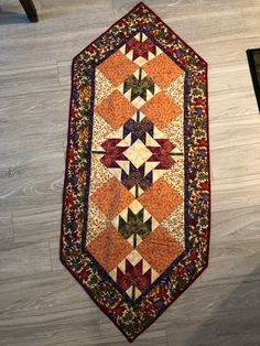 an orange and blue quilt on the floor