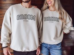 a man and woman standing next to each other wearing matching sweatshirts with the word groom on them