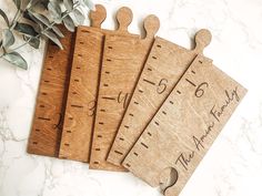 four wooden rulers with engraved date and year on them sitting on a marble counter top