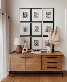 a wooden dresser sitting next to a window with pictures on it