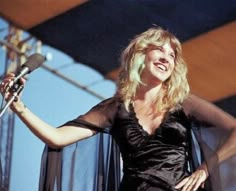 a woman in black dress holding a microphone