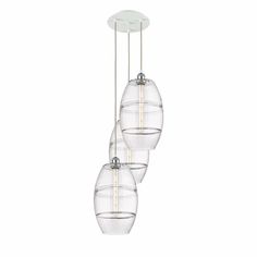 three clear glass globes hanging from a ceiling fixture with one light on each side