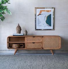 the sideboard is made out of rattan and has an open shelf for storage