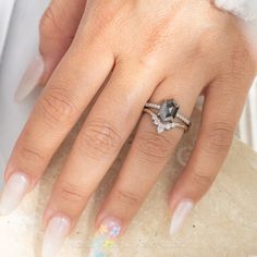 a close up of a person's hand with two rings on their fingers and one is wearing a wedding ring