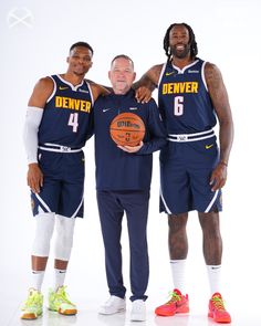 three basketball players are posing for a photo