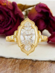 a yellow gold ring with a pear shaped diamond