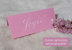 a pink card with the word foye on it next to some purple flowers