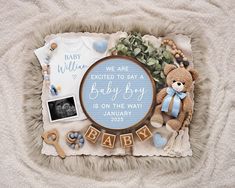 a baby announcement with a teddy bear and other items on a blanket that reads, we are excited to say a baby boy is on the way