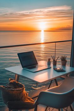 a laptop computer sitting on top of a white table next to a chair and window