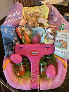 a pink wagon filled with baby items on top of a table