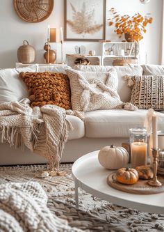 a living room filled with lots of pillows and blankets on top of a white couch