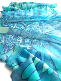 Ocean Blue Wings is a turquoise silk scarves hand painted with bird motif and feathers making a perfect bohemian wedding veil. Think about boho shawl for the bride! Size: 23 by 70 inches (177 by 60 centieters) Silk: pure Habotai Light, semi transparent and a bit glossy. This Wings scarf was designed and hand painted by me as an fashion statement wearable piece of art. The shawl can become a wedding blue veil or a beach pareo or a gorgeous every day scarves. The Blue Wings silk scarf is made to o Bohemian Blue Shawl For Weddings, Bohemian Blue Dupatta For Wedding, Bohemian Blue Silk Scarf As Gift, Bohemian Blue Silk Scarf For Gift, Bohemian Blue Silk Scarf Gift, Blue Silk Scarf For Wedding, Artistic Handmade Blue Silk Scarf, Bohemian Hand Painted Silk Scarves, Blue Hand Painted Bohemian Silk Scarf