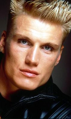 a man with blonde hair wearing a black jacket