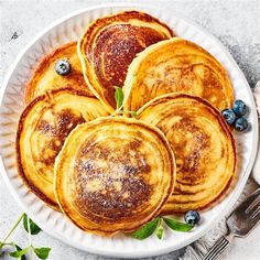 pancakes on a plate with blueberries and mint