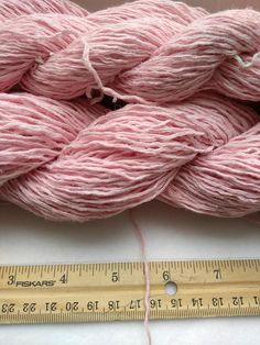 pink skeins of yarn next to a measuring tape