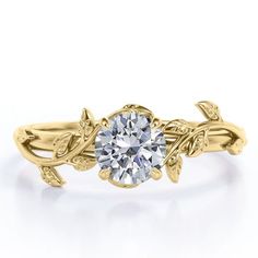 a yellow gold engagement ring with an intricate vine design and a round diamond center stone