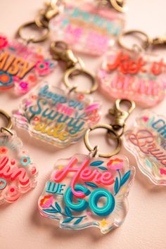 a bunch of key chains that have some type of lettering on them, all in different colors