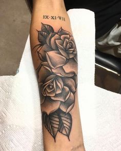 a black and white rose tattoo on the arm