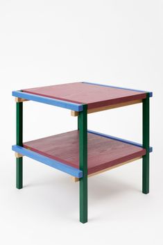 a wooden table with two different colored shelves on each side and one shelf below it