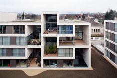 an apartment building with several balconies and plants on the top floor in front of it