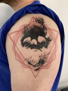 a man with a tattoo on his arm that has an image of a face in the middle