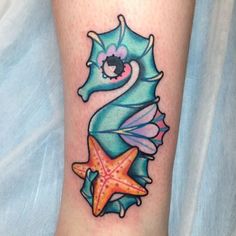 a seahorse tattoo on the leg with starfishs and shells around it's legs