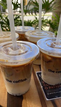 four iced coffees are sitting on a table