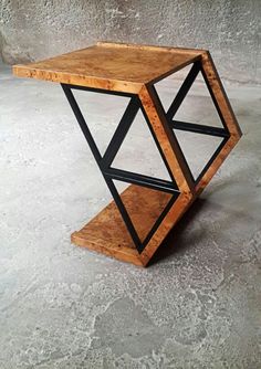 a wooden table with black metal legs and a wood shelf in the middle on concrete flooring