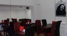 a dining room filled with red chairs and black tables