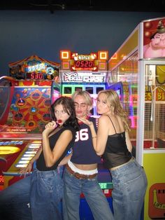 three girls standing in front of a carnival machine