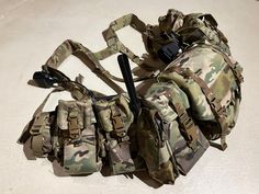 a camouflage bag with two radio pouches attached to it