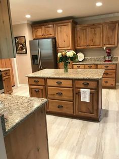 a large kitchen with wooden cabinets and granite counter tops, along with stainless steel appliances