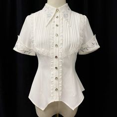 An embroidered blouse that looks like an aristocratic lady from medieval Europe. A cross and a rose are embroidered on the collar, and ivy is also embroidered on the cuffs. The back is decorated with lacework, and the chest is decorated with ruffles, pleats, and lace embroidery. For a young lady with a gorgeous atmosphere. 
 
 

 

 
 
 Color 
 
 White 
 Black 
 
 
 Size 
 
 
 S size 
 
 Length: 60cm 
 Shoulder width: 36cm 
 Bust: 86cm 
 Waist: 68cm 
 Sleeve length: 21.5cm 
 
 M size 
 
 Length: Elegant Fitted Blouse With Peter Pan Collar, White Embroidered Blouse With Peter Pan Collar, White Doll Collar Top With Floral Embroidery, White Floral Embroidered Top With Doll Collar, Elegant Short Sleeve Lace Blouse, Elegant Fitted Lace Blouse, White Fitted Victorian Blouse, Fitted White Victorian Blouse, Elegant White Tops With Lace Collar