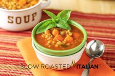 a green bowl filled with soup next to a spoon