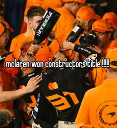 a group of people wearing orange shirts and holding up their hands with the words mclarn won constructors title