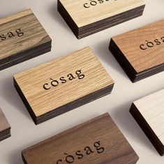 several wooden business cards with the word cosag printed on them, all in different colors