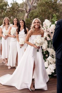 a group of women in white dresses standing next to each other