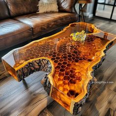 a table made out of honeycombs on top of a wooden floor next to a couch