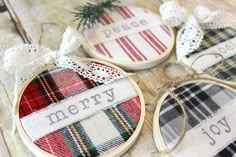 three cross stitch christmas ornaments with the word merry written on each ornament in black, white, red and green plaid