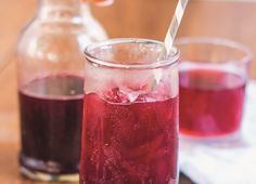 two glasses filled with liquid sitting on top of a wooden table