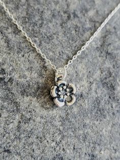 "Tiny sterling silver plum blossom necklace. Our tiny plum blossom necklace is solid sterling silver and has a 3 dimensional flower with an antiqued finish. It hangs from a small but strong sterling silver chain with a sterling spring clasp. The flower measures 8mm across and shown here on a 17\" chain. *If you are unsure of the length you need, or would like to wear this item at different lengths, we now offer an adjustable length option! You can add an adjustable end to your necklace using thi Dainty Silver Charm Necklace With Flower Pendant, Nickel-free Silver Flower Charm Necklace, Silver Flower Charm Necklace With Round Pendant, Delicate Silver Charm Necklace With Flower, Delicate Silver Flower-shaped Charm Necklace, Delicate Silver Flower Shape Charm Necklace, Sterling Silver Charm Necklace With Flower Pendant, Sterling Silver Flower Charm Necklace With Pendant, Sterling Silver Flower Charm Necklaces