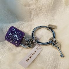 a close up of a key chain on a white blanket with a tag attached to it