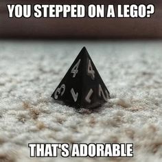 a black dice sitting on top of a carpet covered in white text that reads, you stepped on a lego? that's adorable