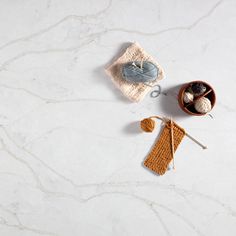 a white marble counter top with crocheted items on it and a knitted dishcloth