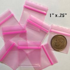 some pink plastic pieces next to a penny