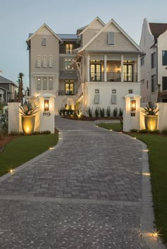 a large white house with lots of lights on it's front yard and driveway